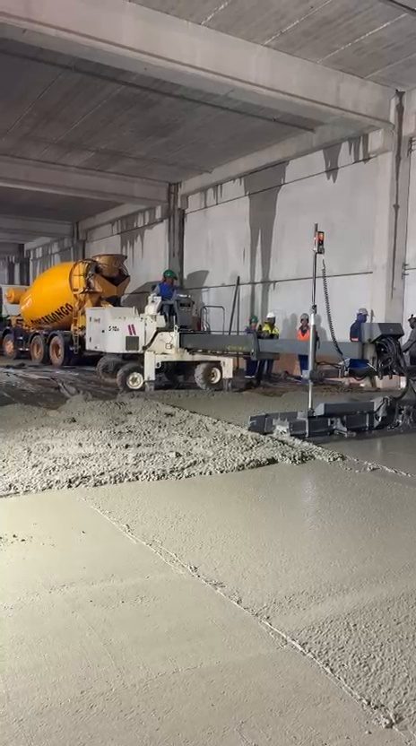 Concretagem de piso industrial com régua laser dentro de galpão